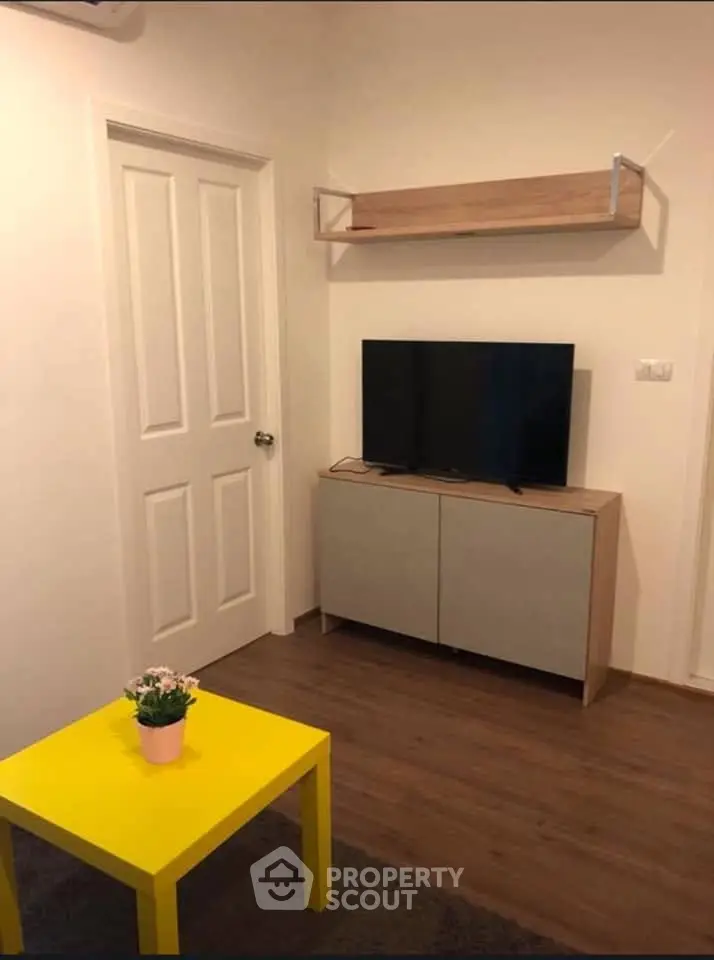 Cozy living room with modern TV stand and vibrant yellow coffee table.