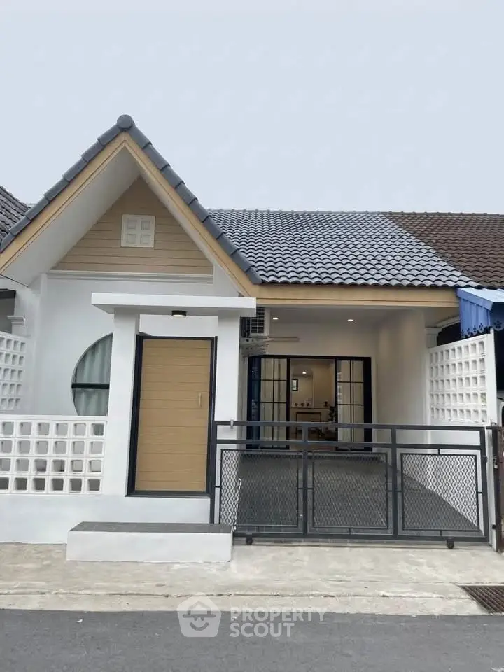 Charming single-story home with modern facade and gated entrance, perfect for cozy living.