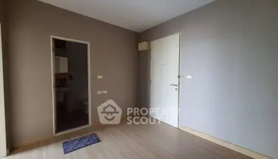Minimalist empty room with wooden flooring and white door, ready for customization.