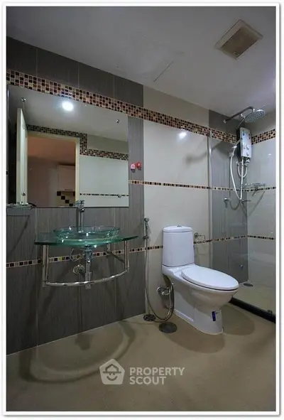 Modern bathroom with glass sink and shower in stylish apartment