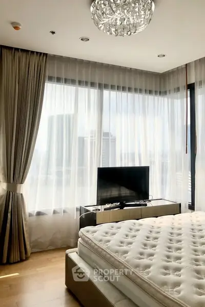 Luxurious bedroom with city view and elegant chandelier