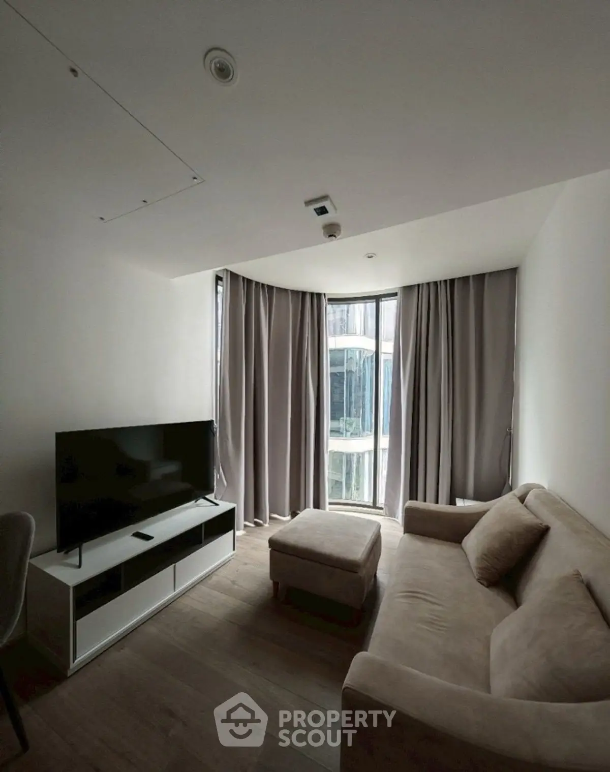 Modern living room with sleek TV setup and cozy sofa in a stylish apartment.