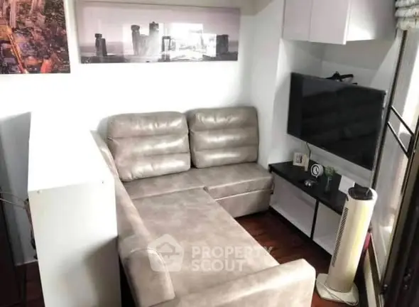 Cozy living room with modern sectional sofa and wall-mounted TV, perfect for relaxation.