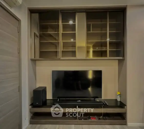 Modern living room with sleek TV unit and ample storage space.