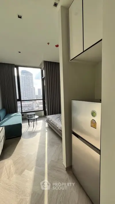 Modern apartment with city view, featuring cozy living area and compact kitchen.