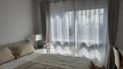 Bright and cozy bedroom with large window and elegant curtains in modern apartment.