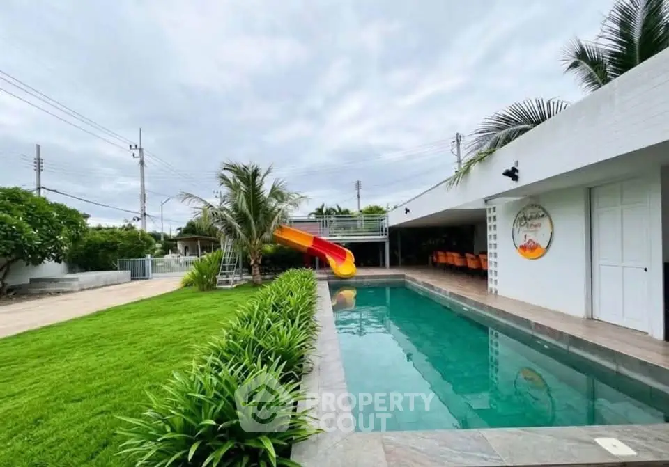 Luxurious property with private pool and slide, lush garden, and modern outdoor amenities.
