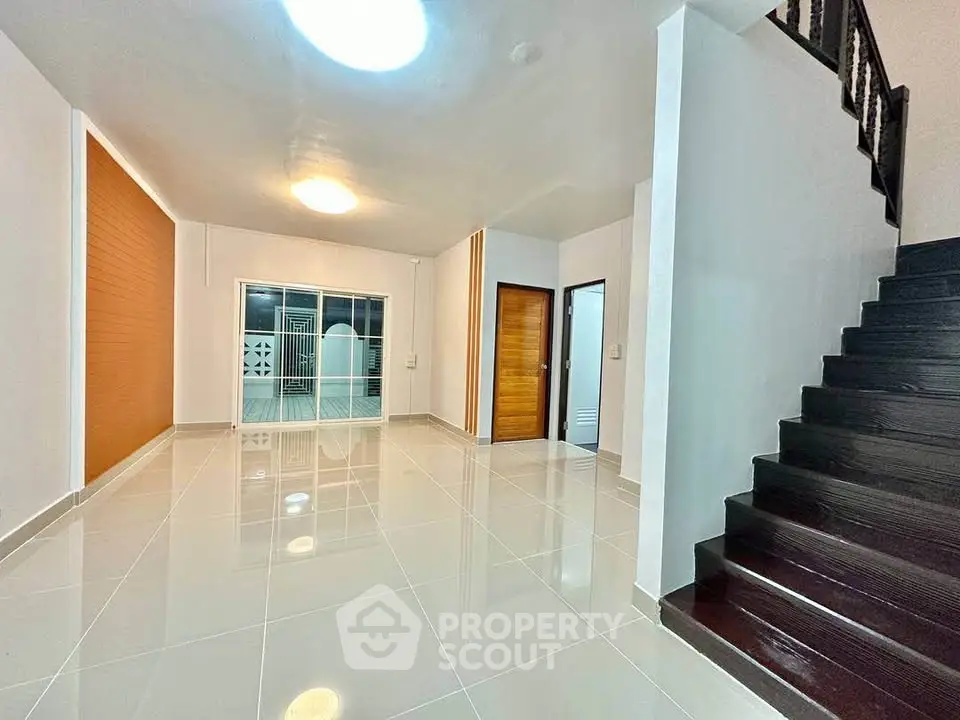 Spacious modern living room with sleek staircase and large windows