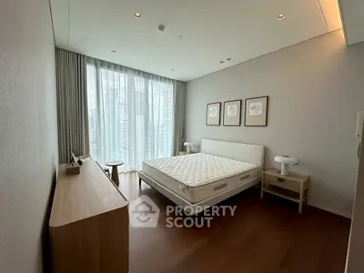 Modern bedroom with large window and minimalist furniture in high-rise apartment.