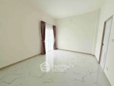 Spacious empty room with marble flooring and large window with curtains