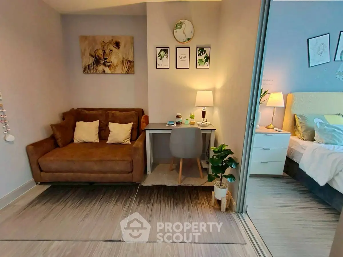 Cozy study nook with plush sofa and stylish decor adjacent to a modern bedroom.