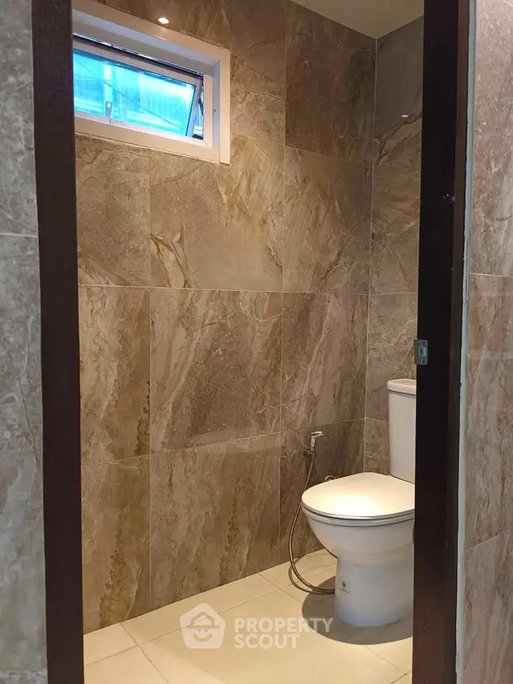 Modern bathroom with elegant stone tiles and sleek toilet design