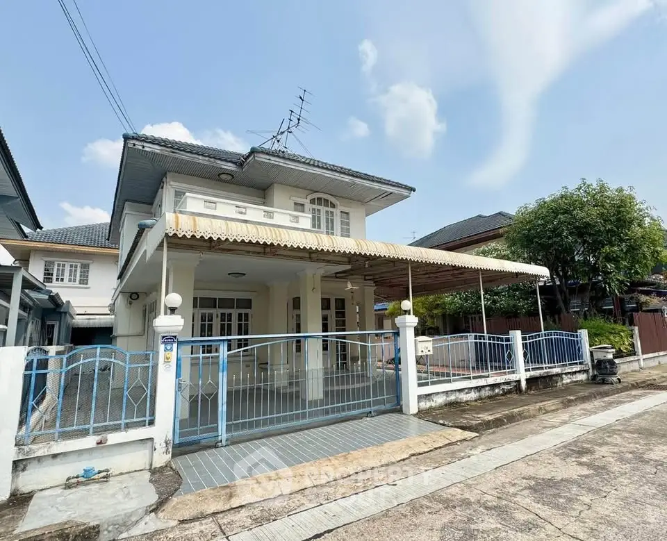 Charming two-story house with a spacious front yard and gated entrance in a serene neighborhood.