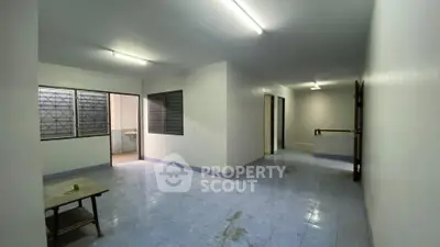 Spacious open-layout living area with tiled flooring and ample natural light.