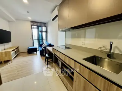 Modern open-layout kitchen and living room with sleek design and natural light.