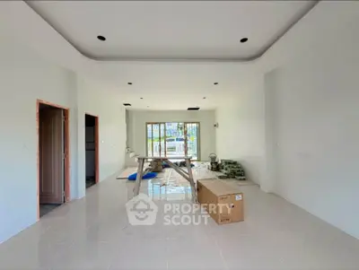 Spacious unfinished living room with large windows and tiled floor, ready for customization.