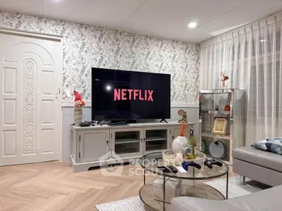 Stylish living room with modern decor and large TV setup, perfect for entertainment.