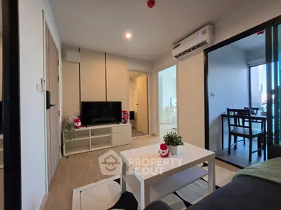 Modern living room with stylish decor and natural light, featuring a cozy seating area and sleek furniture.