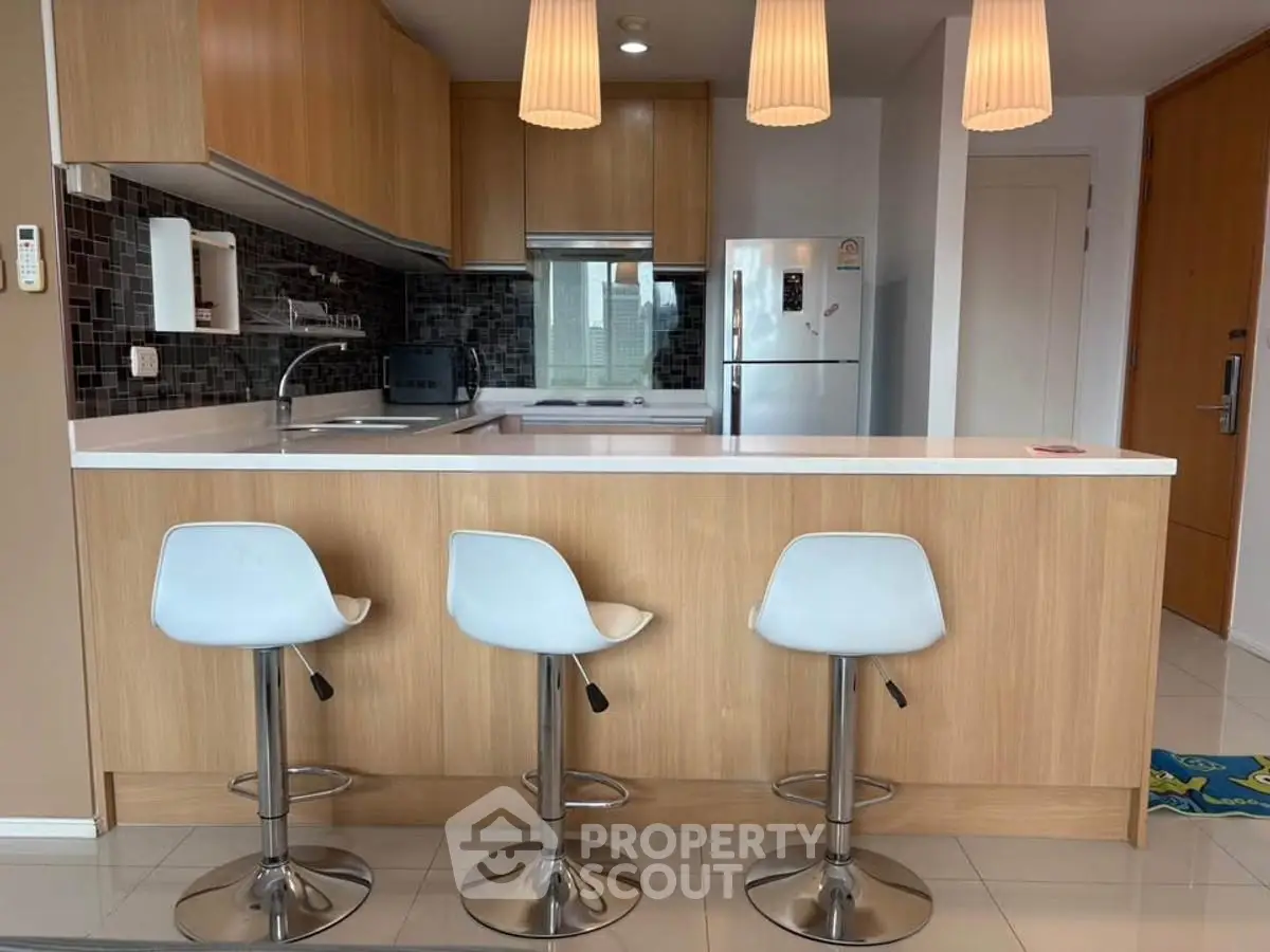 Modern kitchen with sleek wooden cabinets and stylish bar stools