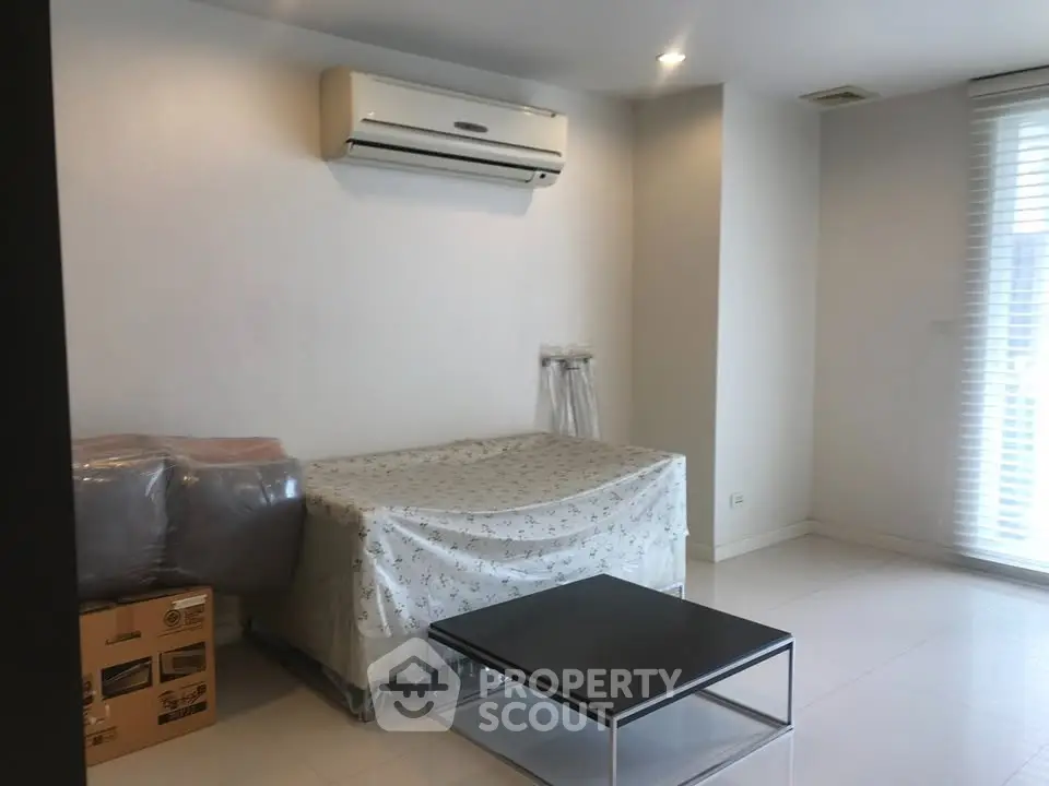 Modern minimalist living room with air conditioning and sleek furniture.