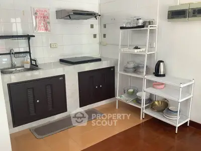 Charming kitchen with open shelving and modern appliances in cozy apartment.
