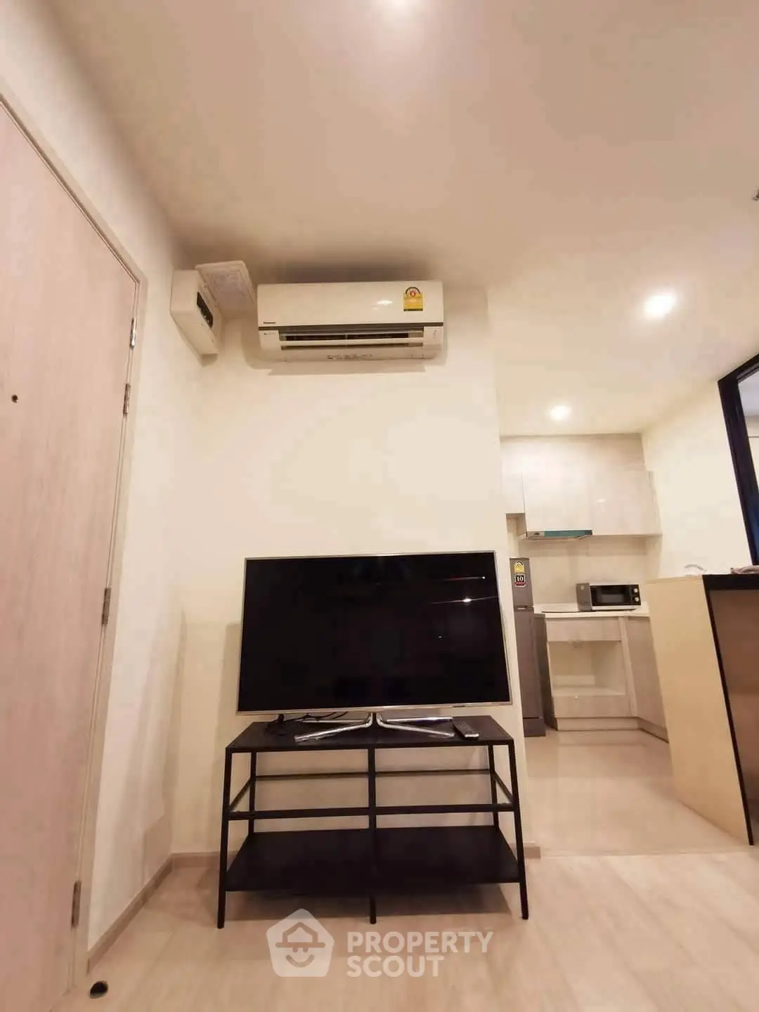 Modern living room with air conditioning and sleek TV setup in a stylish apartment.