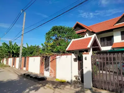 Charming suburban house with red-tiled roof and lush greenery, perfect for family living.