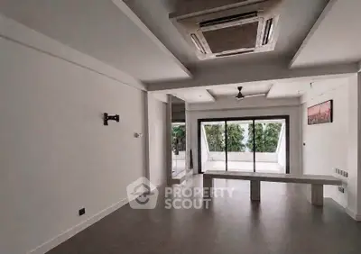 Spacious modern living room with large windows and minimalist decor.