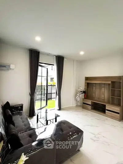 Modern living room with sleek furniture and large windows offering natural light.
