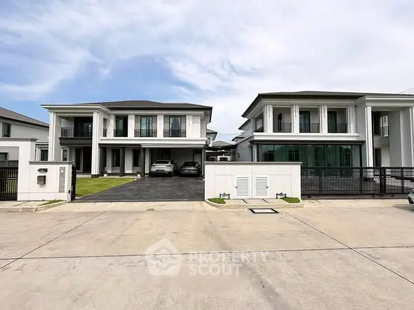 Luxurious modern homes with spacious driveways and elegant architecture in a serene neighborhood.
