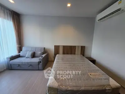 Modern bedroom with cozy sofa and air conditioning in a stylish apartment.