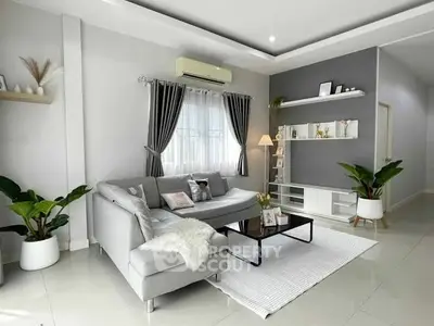 Modern living room with sleek gray sofa, stylish decor, and natural light.