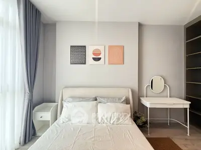 Modern bedroom with stylish decor and natural light, featuring a cozy bed and elegant furnishings.