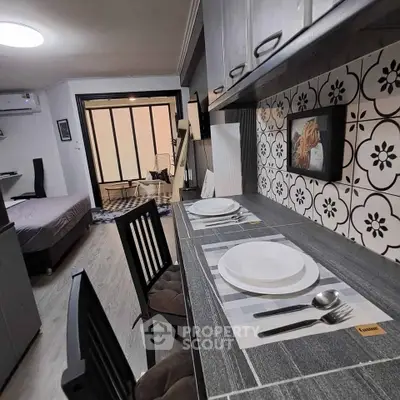 Modern studio apartment with stylish kitchen and cozy living area, perfect for urban living.
