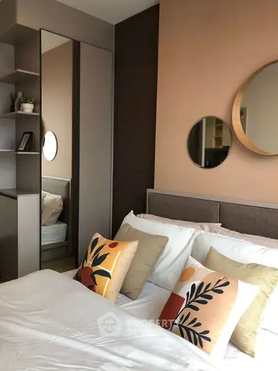 Stylish bedroom with modern decor and cozy pillows in a contemporary apartment.