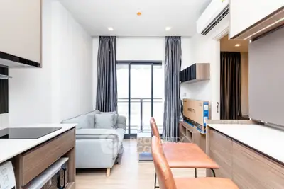 Modern living room with sleek furniture and balcony view in a stylish apartment.