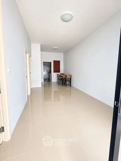 Spacious modern apartment with sleek tiled flooring and minimalist dining area.