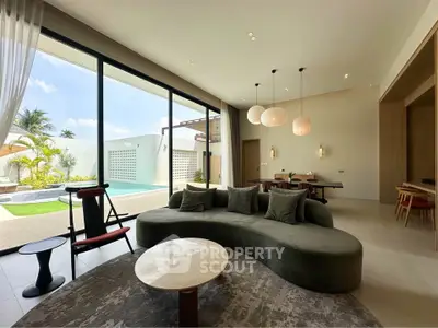 Luxurious living room with modern furniture and pool view, perfect for relaxation and entertainment.