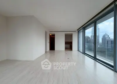 Spacious modern living room with floor-to-ceiling windows and city skyline view.