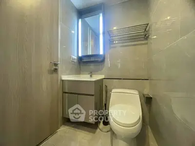 Modern bathroom with sleek fixtures and illuminated mirror in a contemporary apartment.