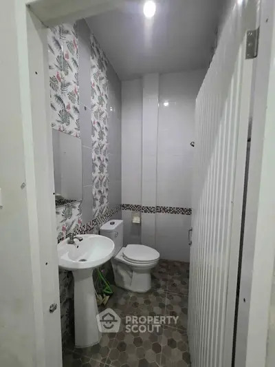 Charming bathroom with floral wallpaper and modern fixtures, perfect for a cozy home.