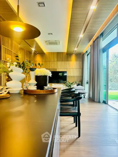 Luxurious modern living room with elegant decor and large windows overlooking a lush garden.