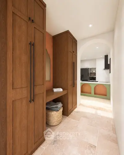 Charming hallway with wooden cabinets leading to a modern kitchen with archway entrance.