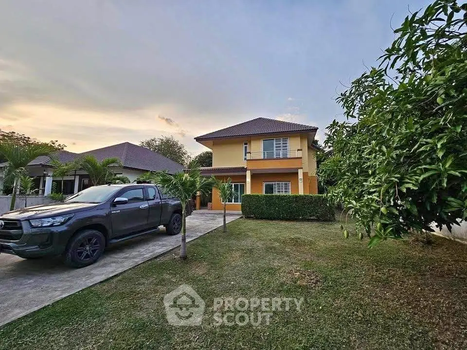 Charming two-story house with spacious driveway and lush garden in serene neighborhood.