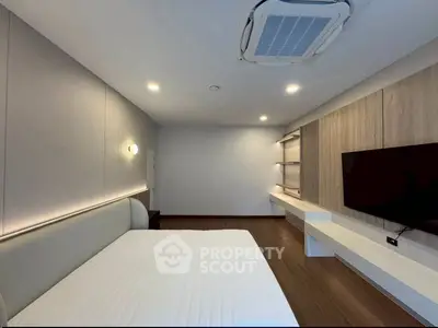 Modern bedroom with sleek design, wall-mounted TV, and ambient lighting.