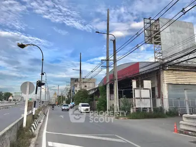 Industrial warehouse exterior with street view and clear blue sky