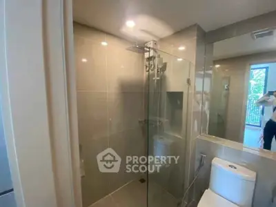 Modern bathroom with glass shower and sleek fixtures in a contemporary home.
