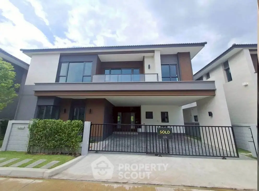 Modern two-story house with sleek design and spacious driveway, recently sold.