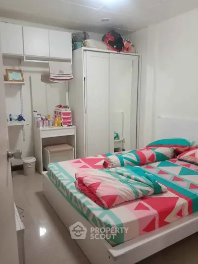Cozy bedroom with colorful bedding and ample storage space
