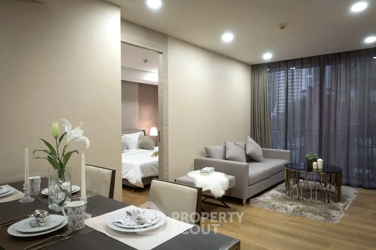 Modern open-plan living room with elegant dining area and cozy bedroom view